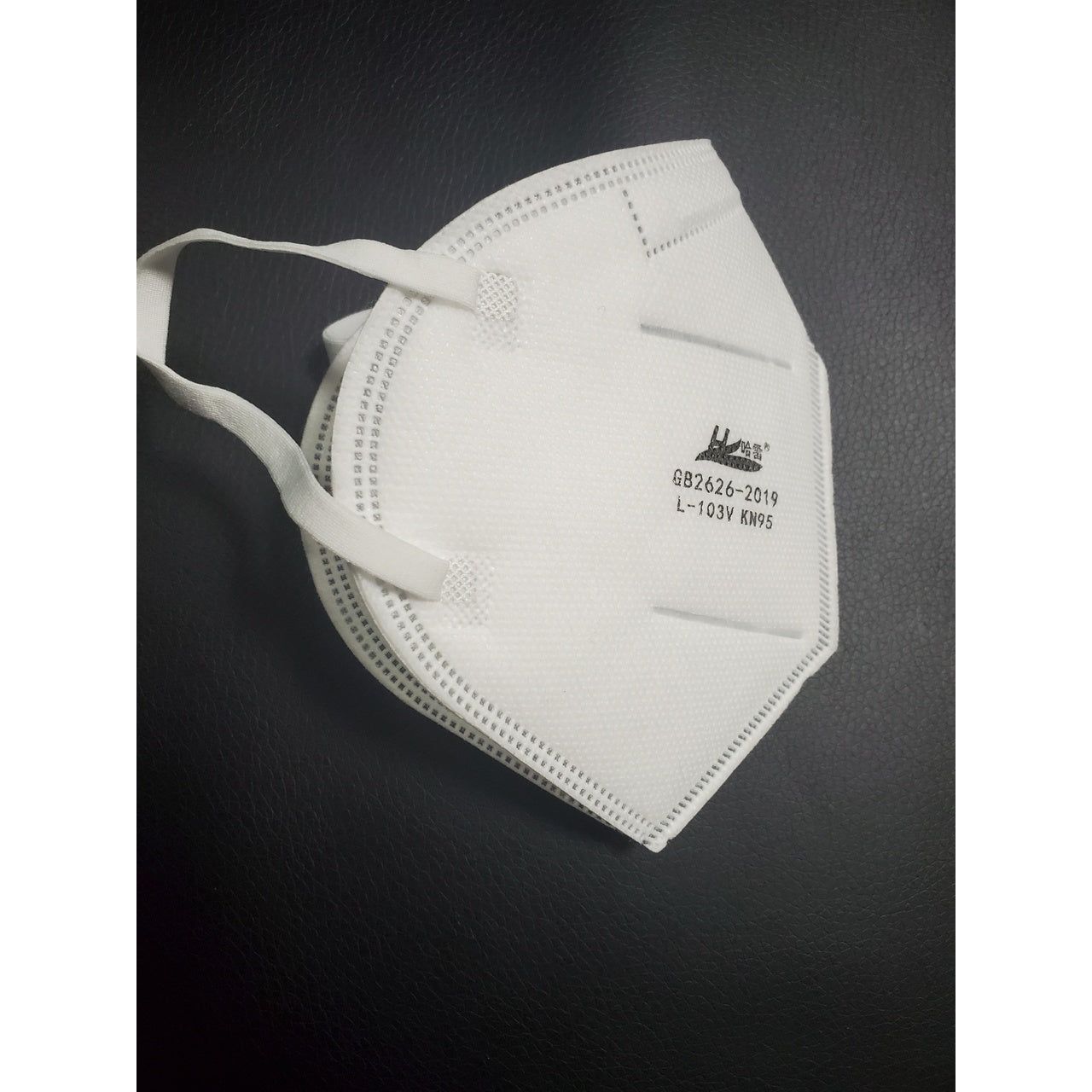 Side view of white Powecom KN95 face mask laid flat