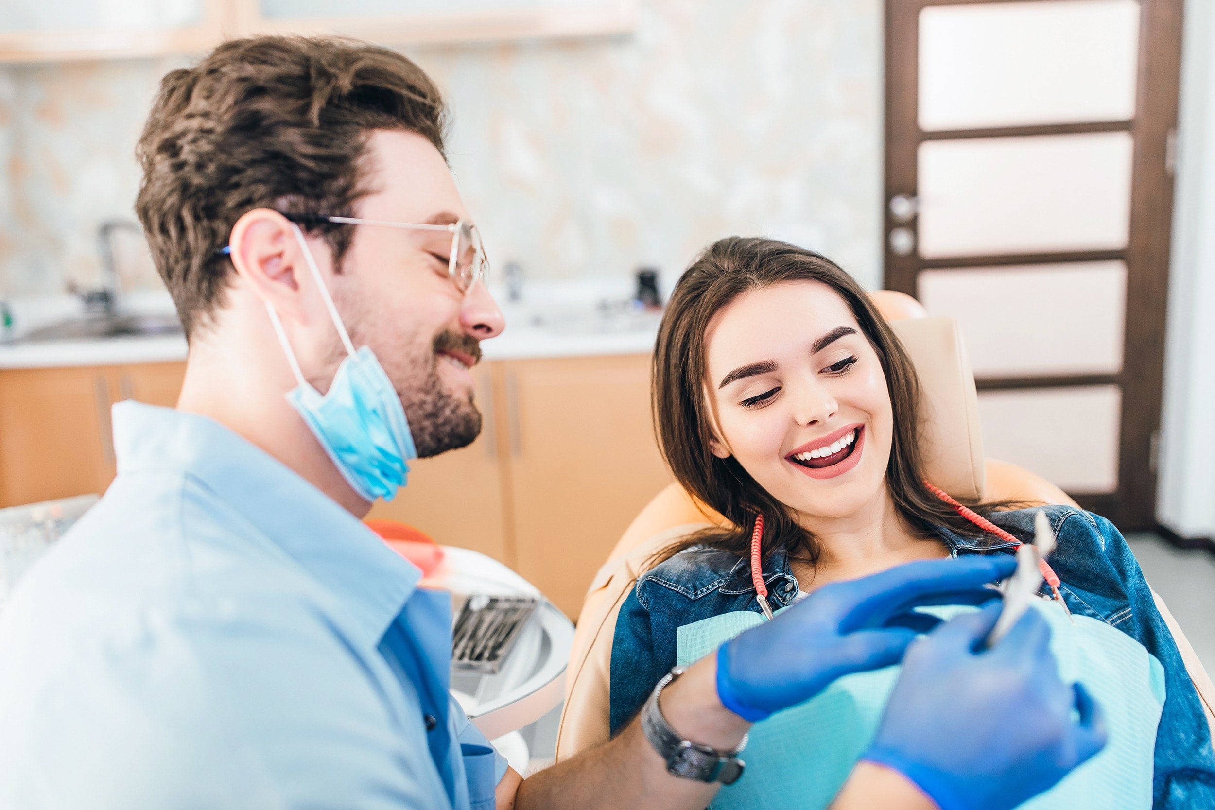Smiling dentist showing chart to patient