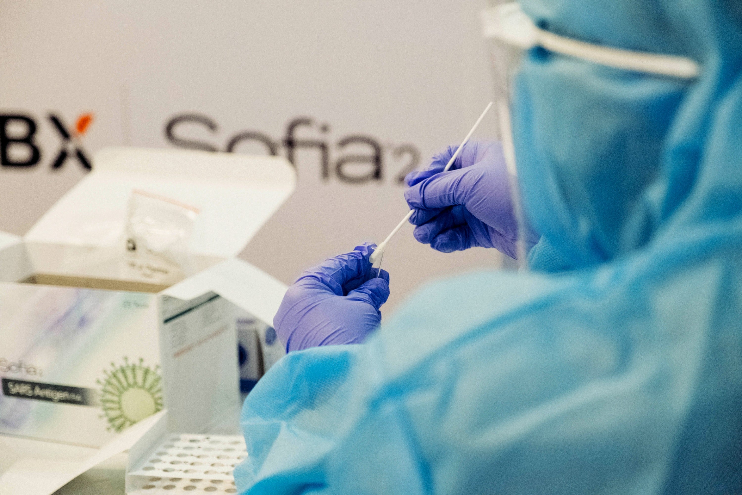 lab technician wearing gloves holding cotton swab